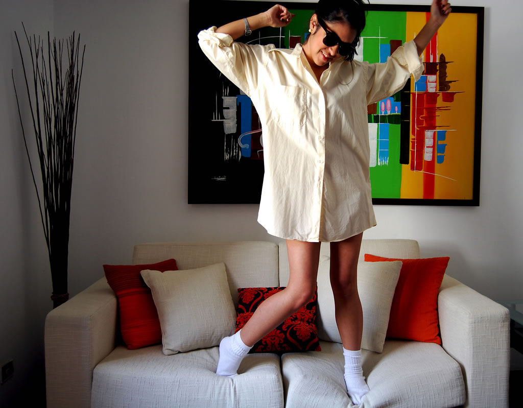 Chica bailando en casa saltando encima del sofá